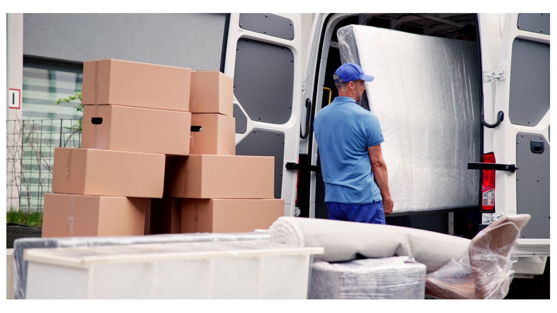 Mover wrapping a mattress and loading boxes into a moving van for a coastal Texas move