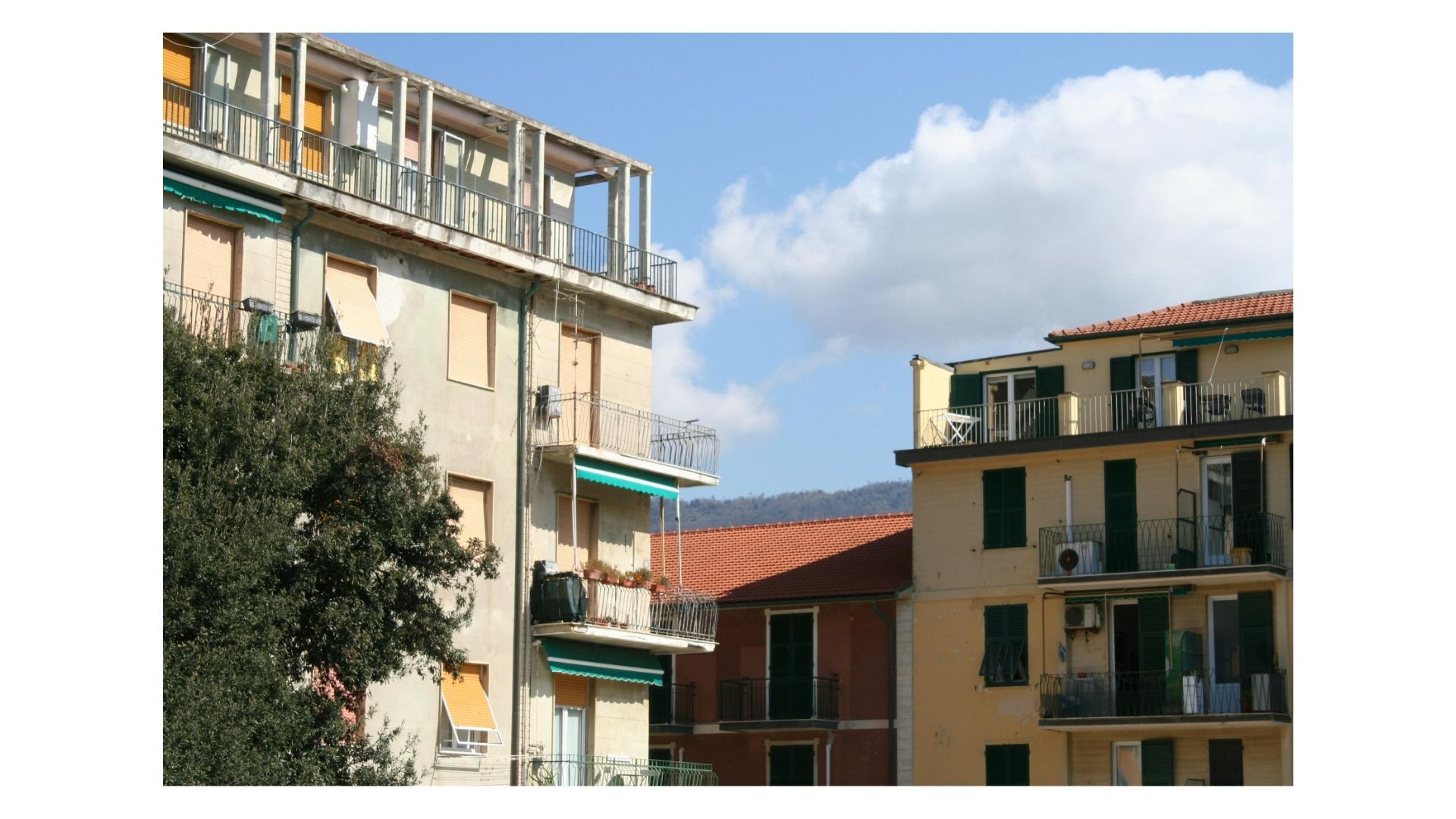Sunlit residential apartment buildings with balconies on a clear day