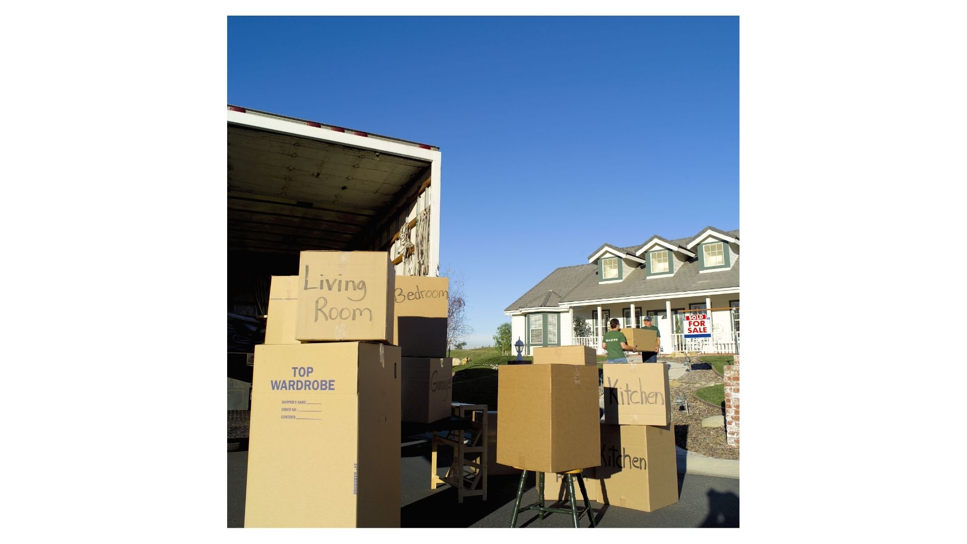 Labeled moving boxes and an open moving truck outside a Hill Country home with a Sold sign, ready for a move to Boerne