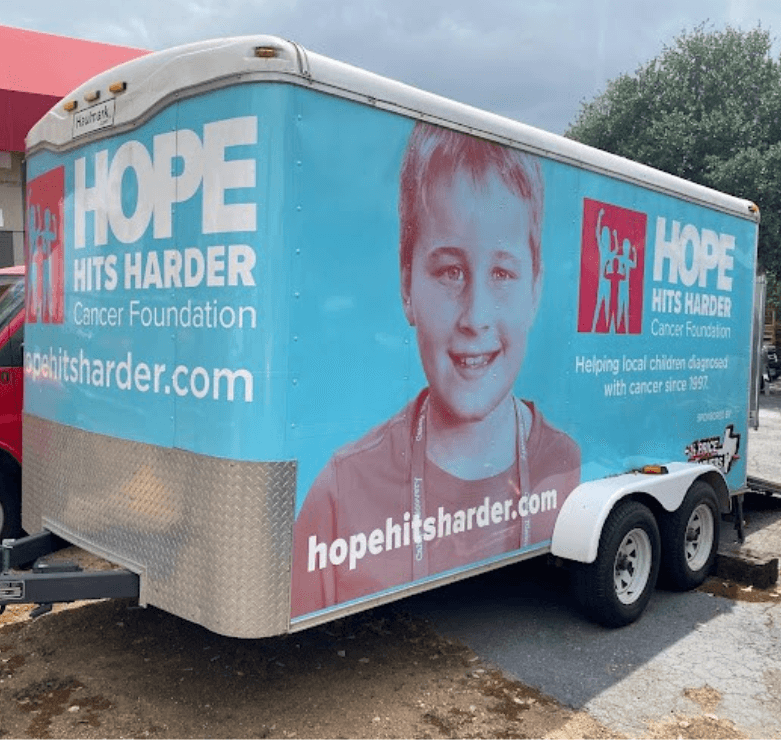 Half Price Movers crew and volunteers in front of branded HPM truck at Snack Pak event